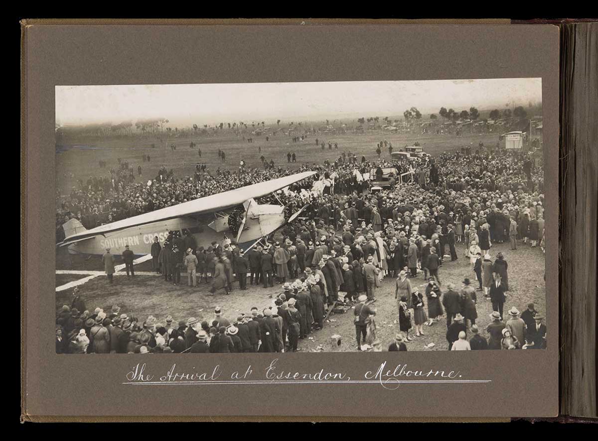 Black and white photo of the 'Southern Cross' with welcoming crowds at Essendon. - click to view larger image