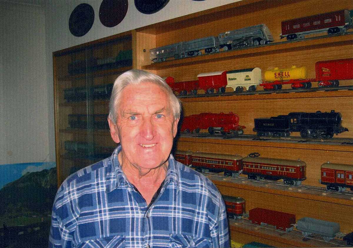 A colour photograph of Bruce Macdonald with his train collection. - click to view larger image
