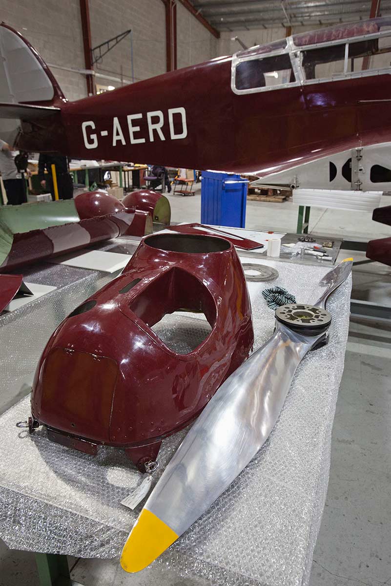 Maroon and silver Percival Type D3 Gull Six three seat cabin monoplane under maintenance in the workshop. - click to view larger image