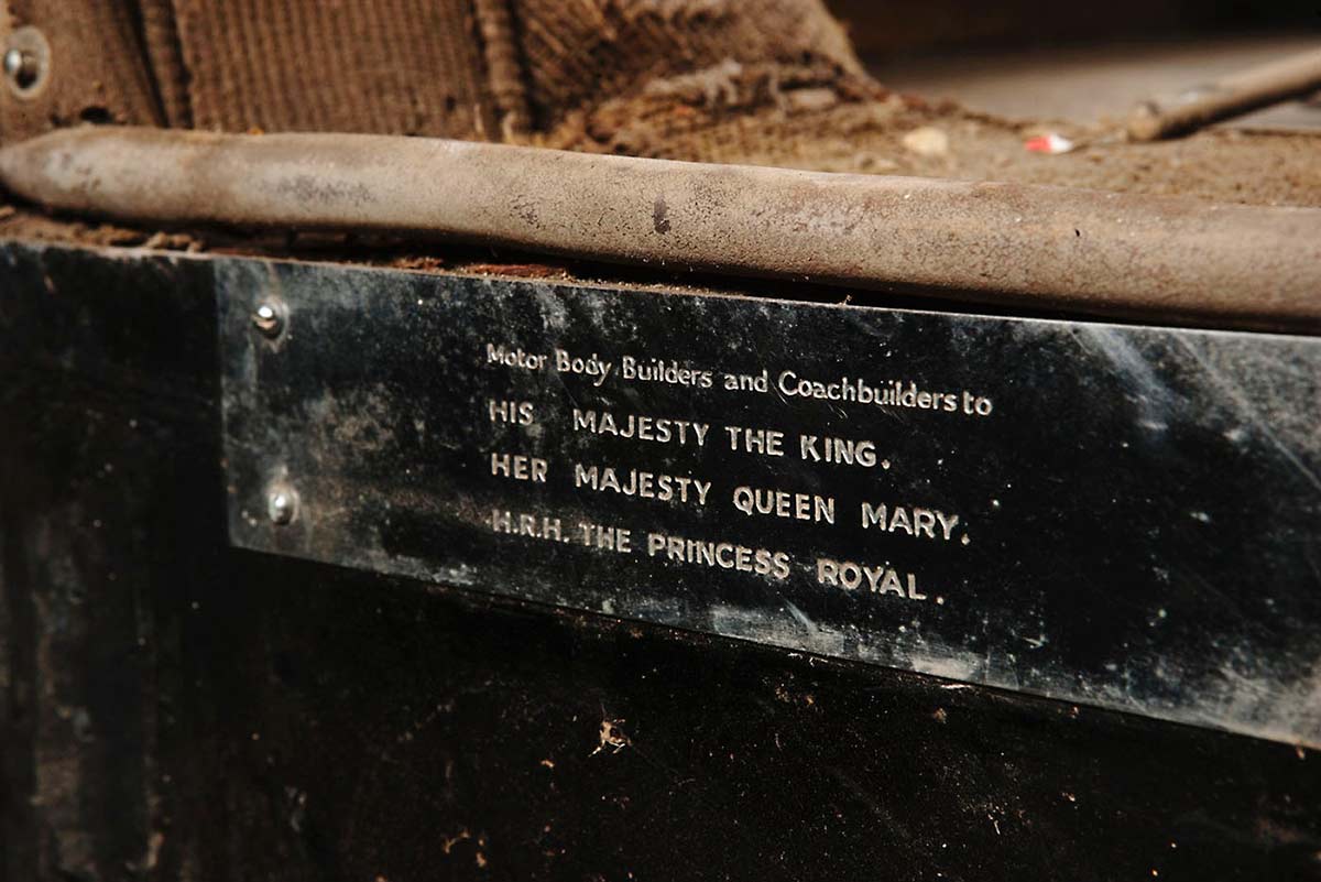 A metal plate attached to the bodywork of an historic vehicle. Text on the plate says 'Motor Body Builders and Coachbuilders to His Majesty The King, Her Majesty Queen Mary, H.R.H. The Princess Royal.' - click to view larger image