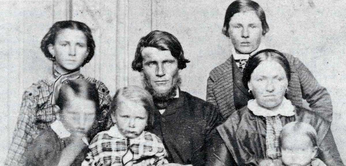 Black and white portrait showing a man and woman and five children.