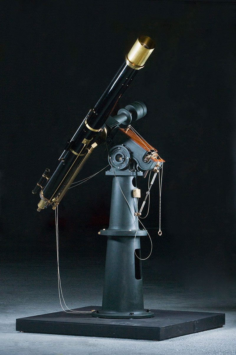 A black telescope made from cast iron and brass attached to a grey cast iron base. - click to view larger image