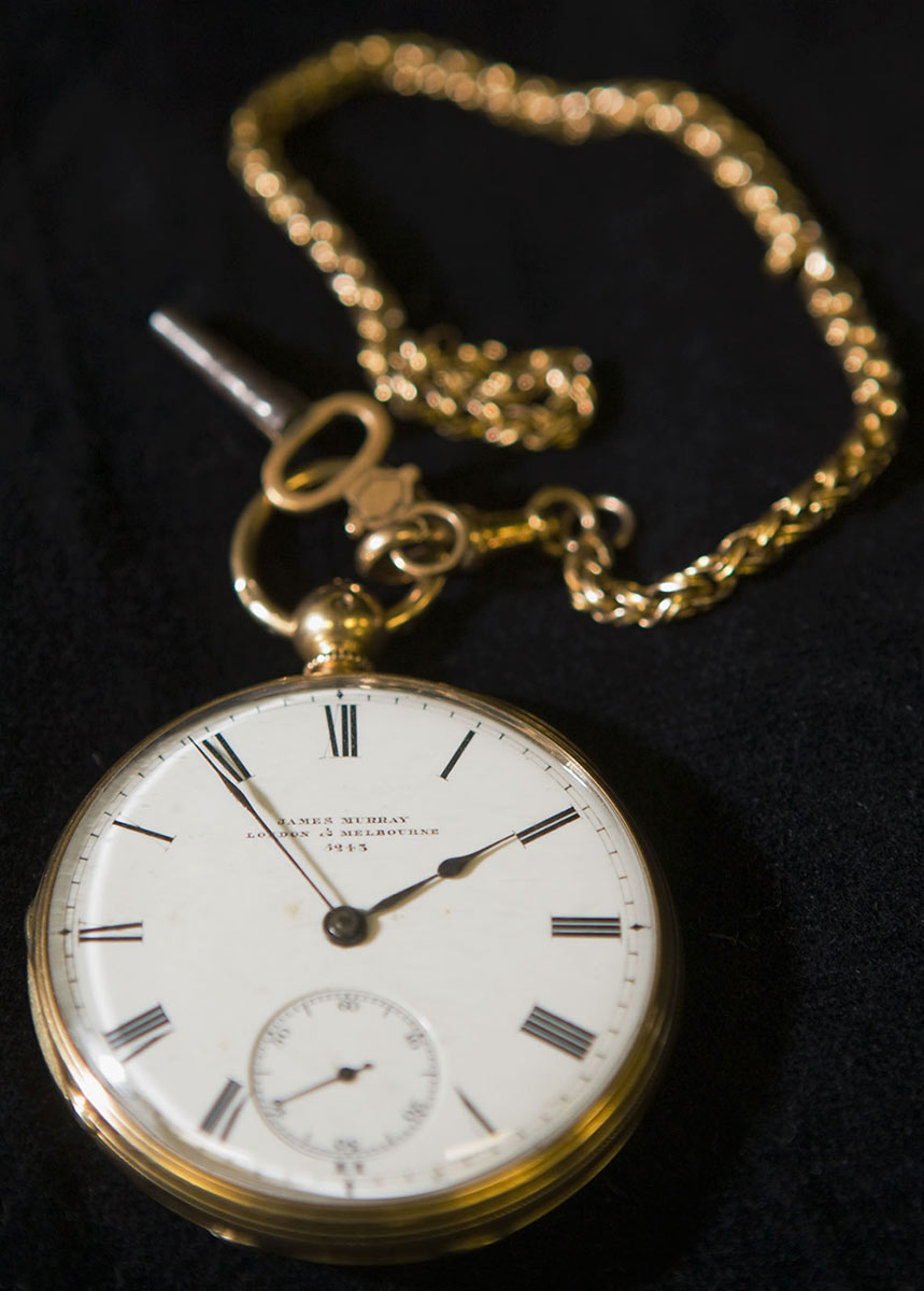 An open face pocket watch with an attached gold chain and key. - click to view larger image
