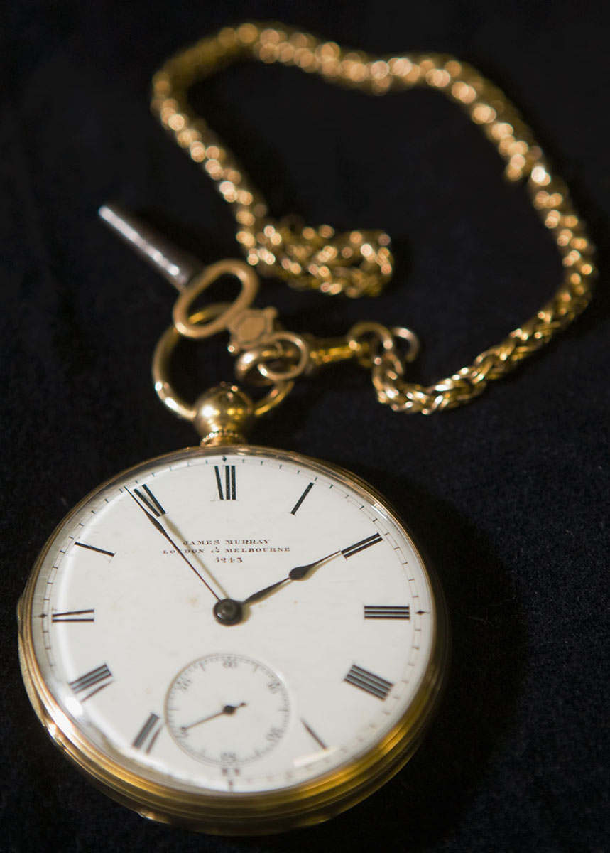 An open face pocket watch with an attached gold chain and key - click to view larger image