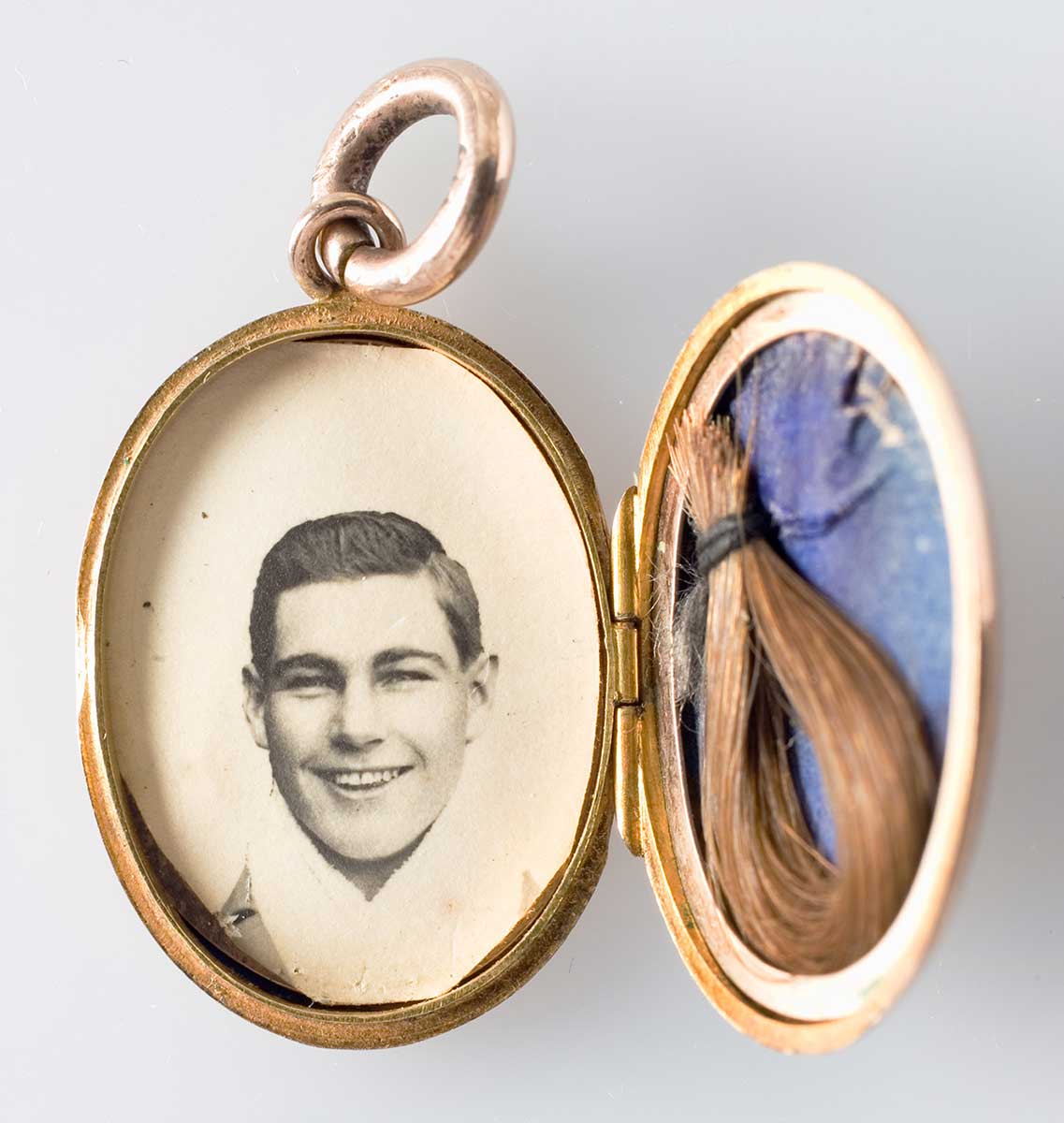 Images of the mourning locket, open and revealing a photo of Les Darcy (on left) and a lock of his hair on a blue background (on right). - click to view larger image
