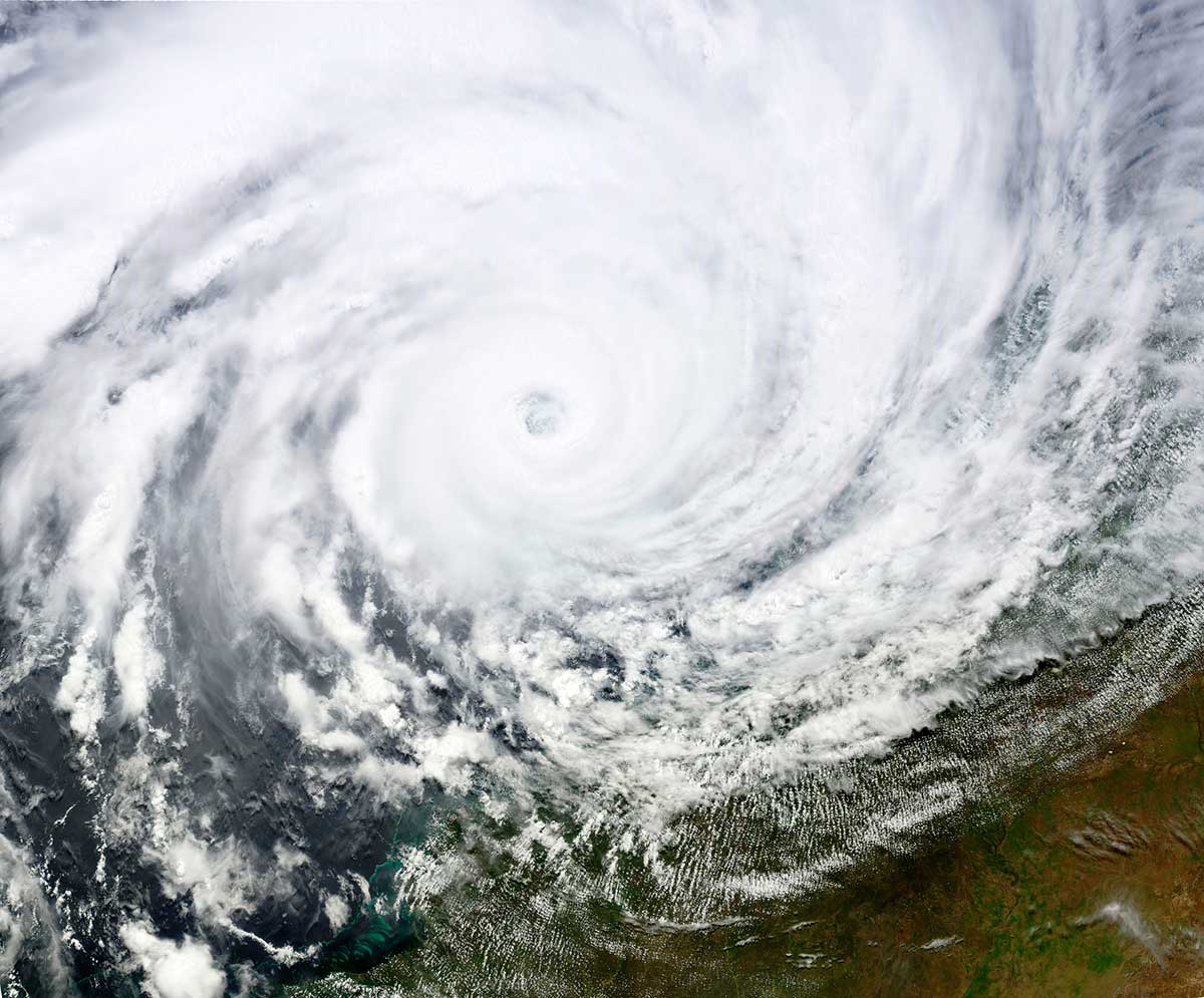 Colour photo of a cyclone above land.