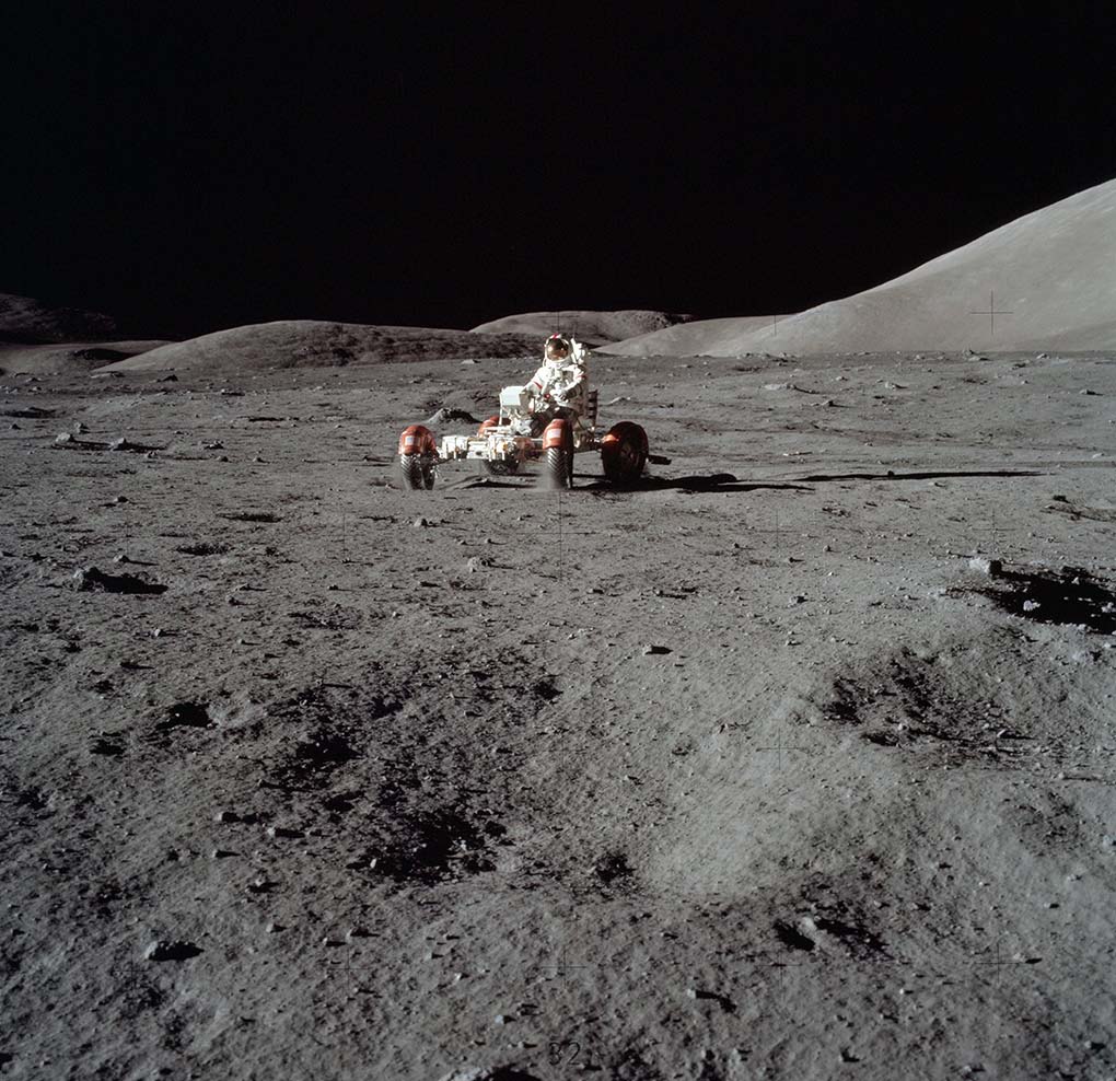 A photograph featuring an astronaut operating a vehicle on the Moon's landscape. - click to view larger image