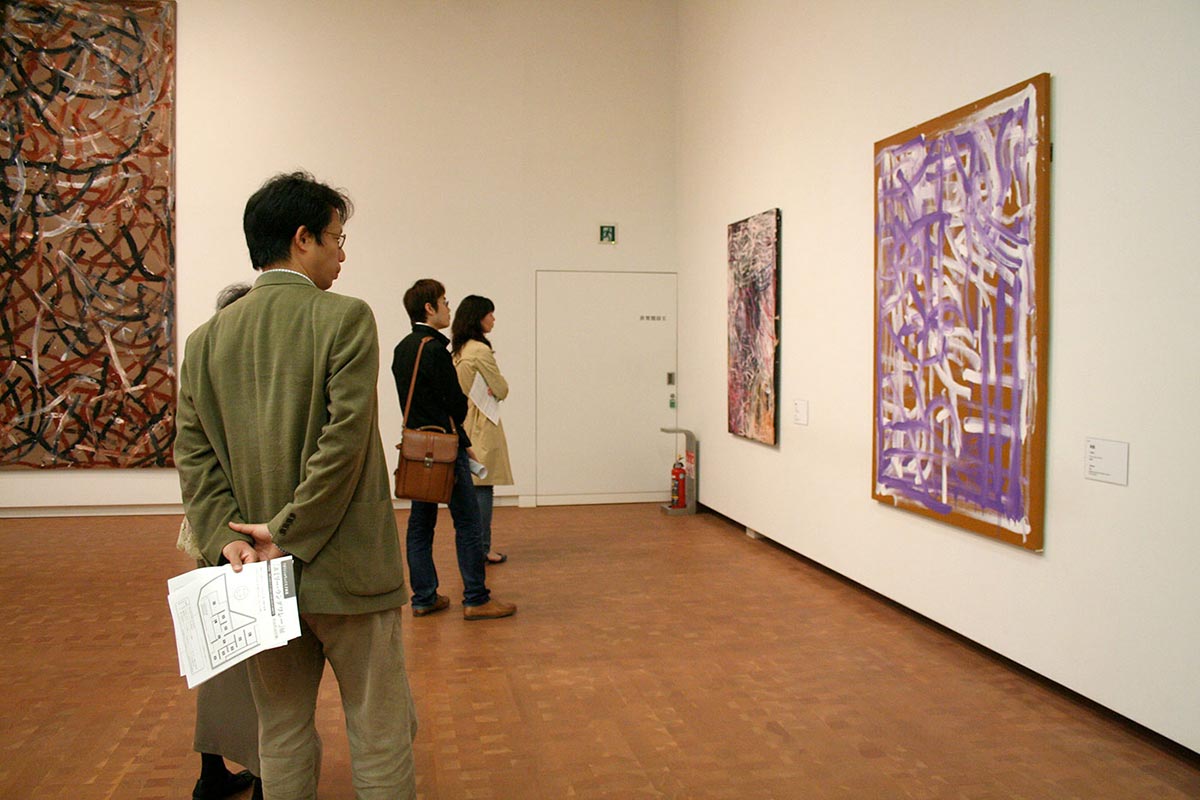 Visitors in an exhibition space viewing art works. - click to view larger image