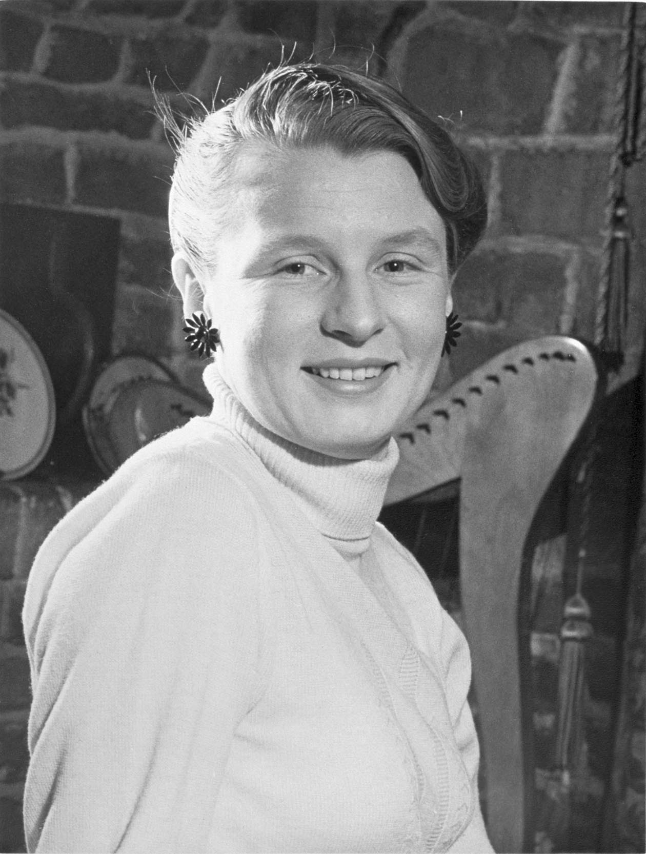 Black and white photo of a young woman in a white high-necked jumper - click to view larger image