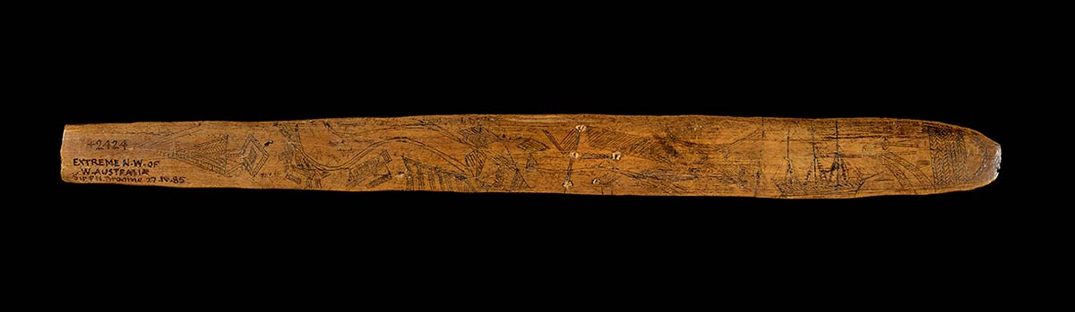 Wooden message stick  engraved with motifs and handwritten text on one end reading ‘EXTREME N.W. OF W. AUSTRALIA’.
