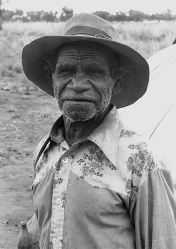 Portrait photo of an Aboriginal Australian man in a hat and shirt. - click to view larger image
