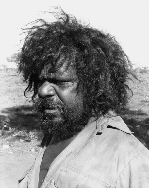 Portrait photo of an Aboriginal Australian man looking to one side. - click to view larger image