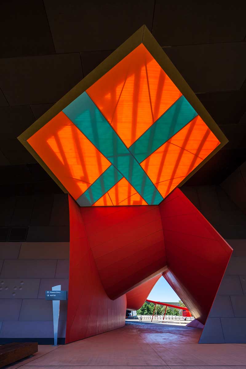 An architectural feature with a large orange filled diamond shape with a teal coloured cross through the middle.