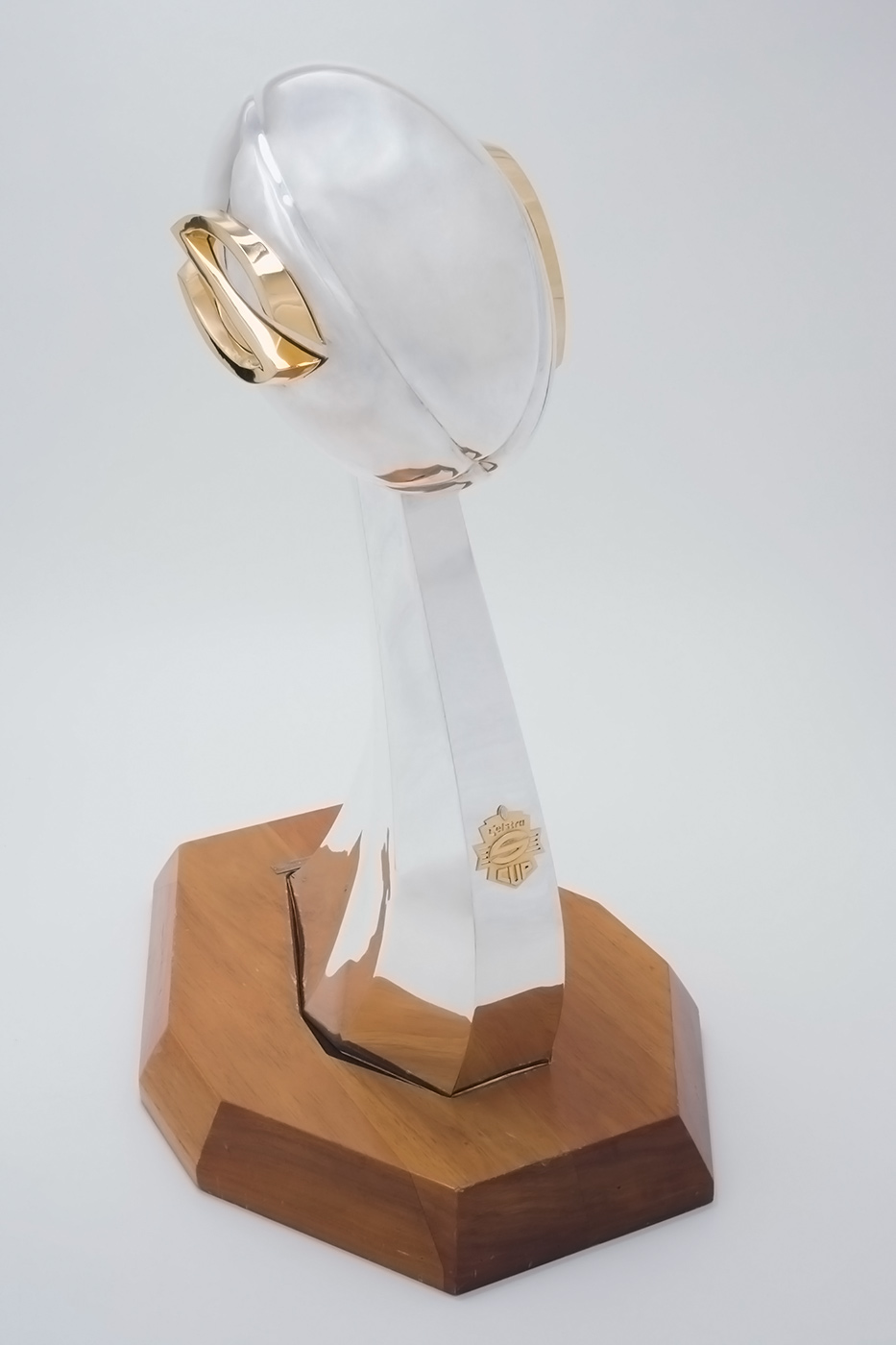 Trophy with a silver football extendeding above a wooden base. - click to view larger image