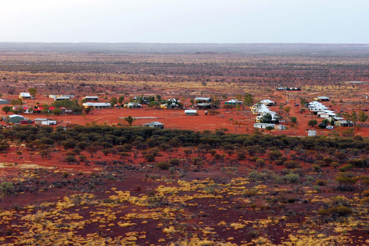 Colour photograph featuring a township surrounded by vast flat land and brush.