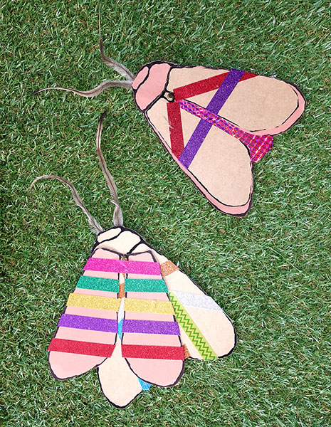 Colour photo of two colourful decorated paper moths.