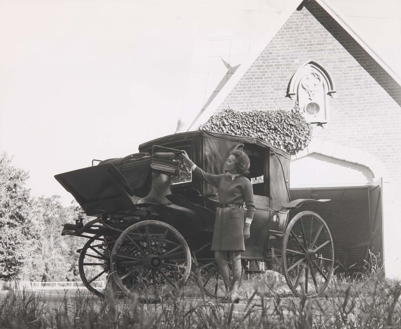 A black and white photo of Pamela Maple-Brown with a landau carriage. - click to view larger image