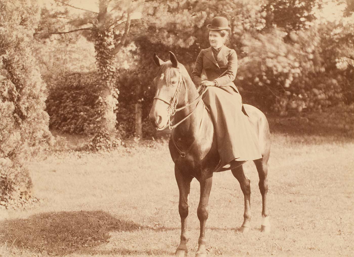 A black and white photograph that depicts Constance Faithfull sitting side-saddle on a horse. - click to view larger image