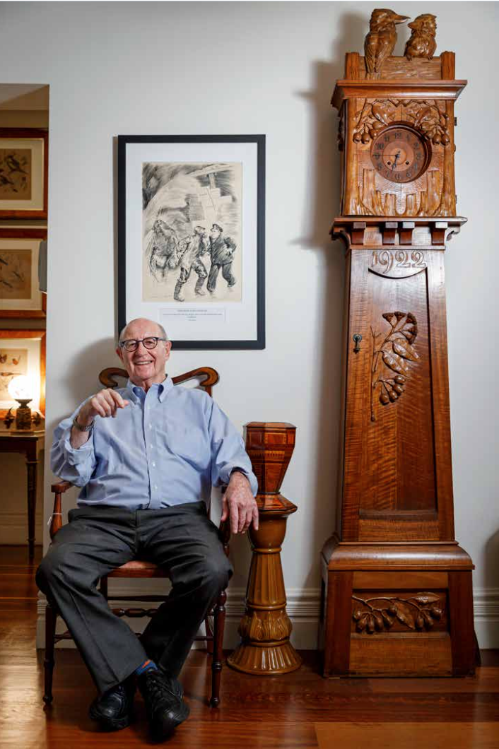Trevor Kennedy sitting on a chair next to a longcase clock. - click to view larger image