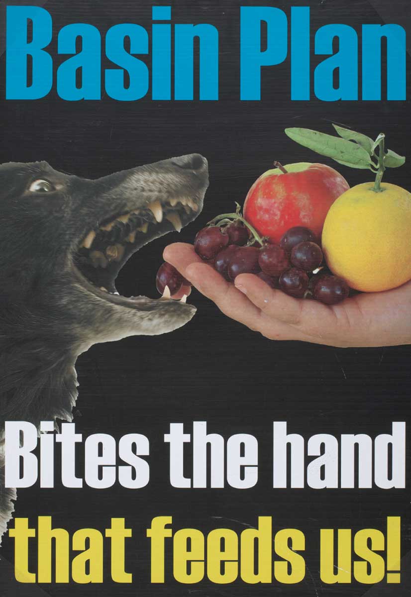 Colour poster with text ‘Basin Plan / Bites the hand’. There is a collaged image of a hand holding various fruit extended towards a dog bearing its teeth. - click to view larger image