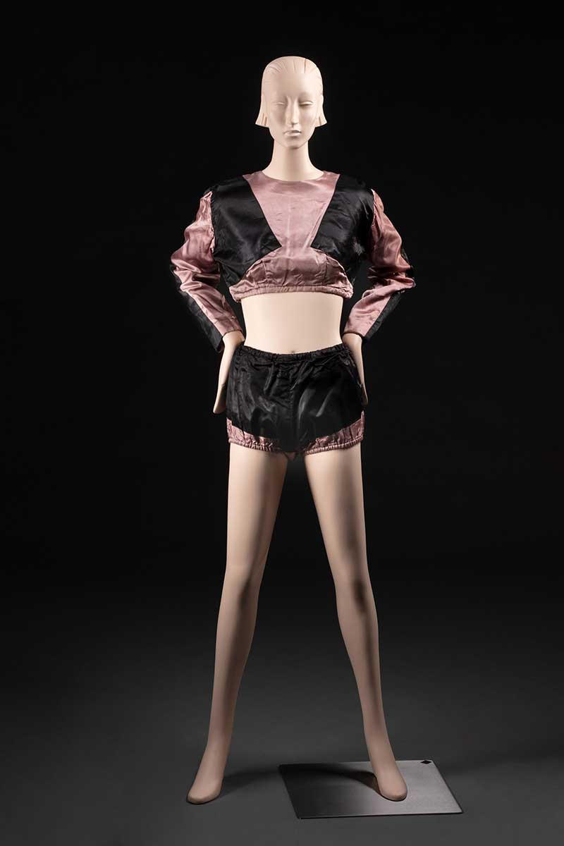 Black and salmon pink costume with crop top and bloomers, displayed on a mannequin. - click to view larger image