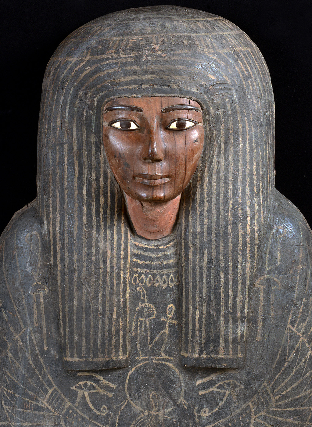 Top part of a coffin shaped in female form, with facial details painted on and various hieroglyphics painted on the chest and shoulders. - click to view larger image