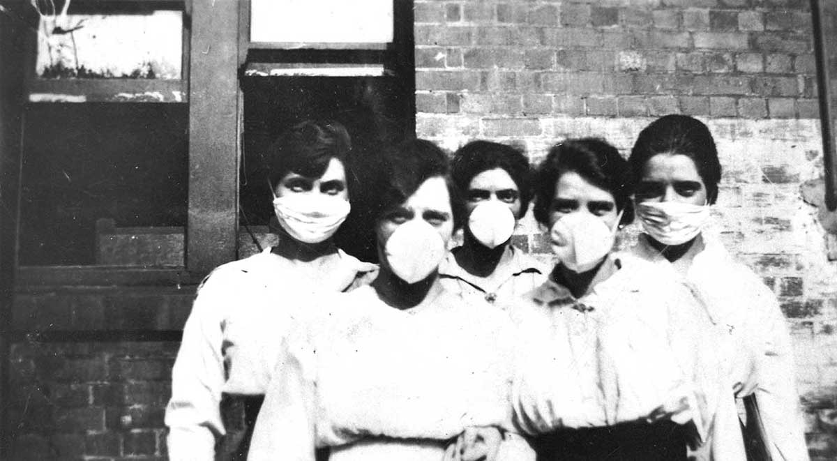 Black and white photograph of five women wearing surgical masks.