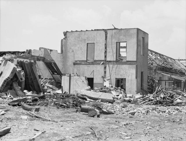 A badly damaged building, surrounded by rubble.