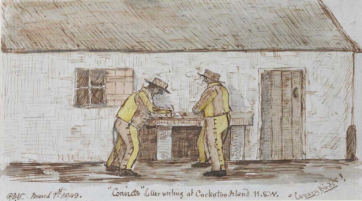 two men in yellow outfits stand writing at a table immediately outside a cottage - click to view larger image