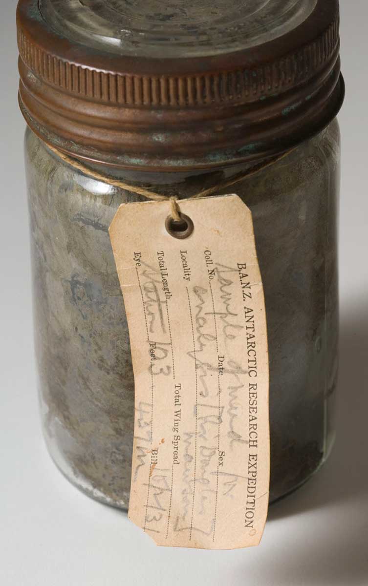 Metal jar and lid with a label for B.A.N.Z Antarctic Research Expedition.  - click to view larger image