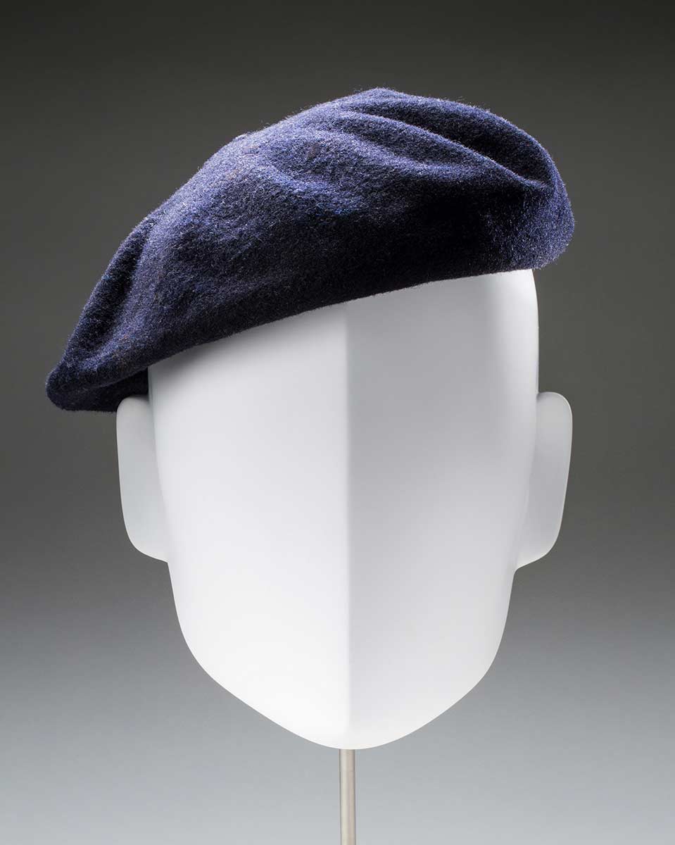 A blue grey beret on a white mannequin. - click to view larger image