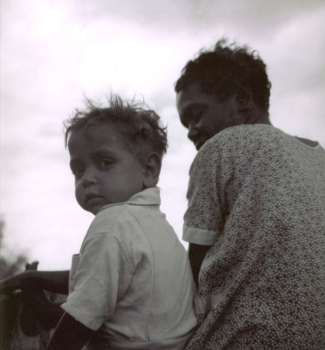 Black and white photo of a young boy with his mother. - click to view larger image