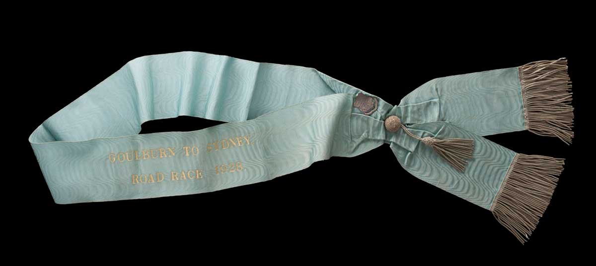 Light blue sash with silver fringing and gold lettering. - click to view larger image