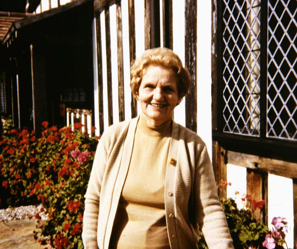 Molly Goodall standing outside of a house. - click to view larger image