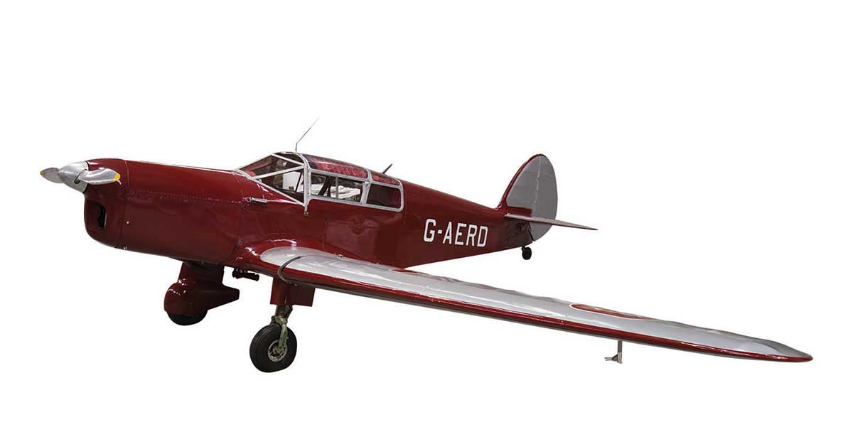 Photograph of a monoplane, deep red in colour, with silver wings and rudder. The aircraft has the registration 'G-AERD' in white at the far end of the fuselage.