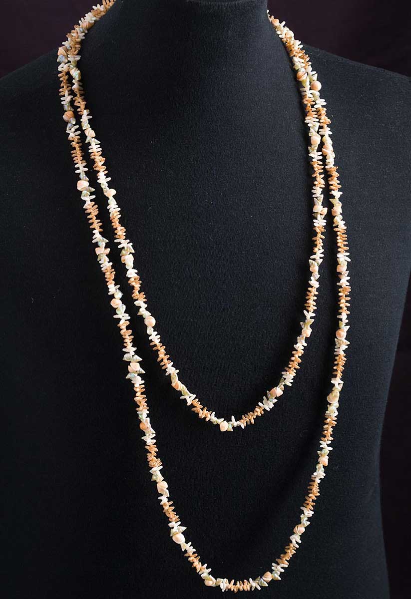 A necklace made from sea shells displayed on a dressmaker's dummy. - click to view larger image