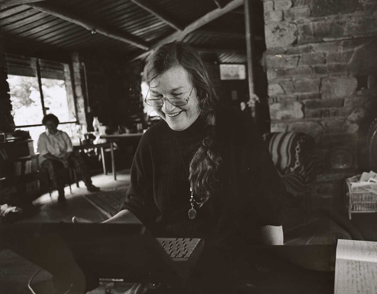 Val Plumwood sitting at her desk in front of a laptop. - click to view larger image