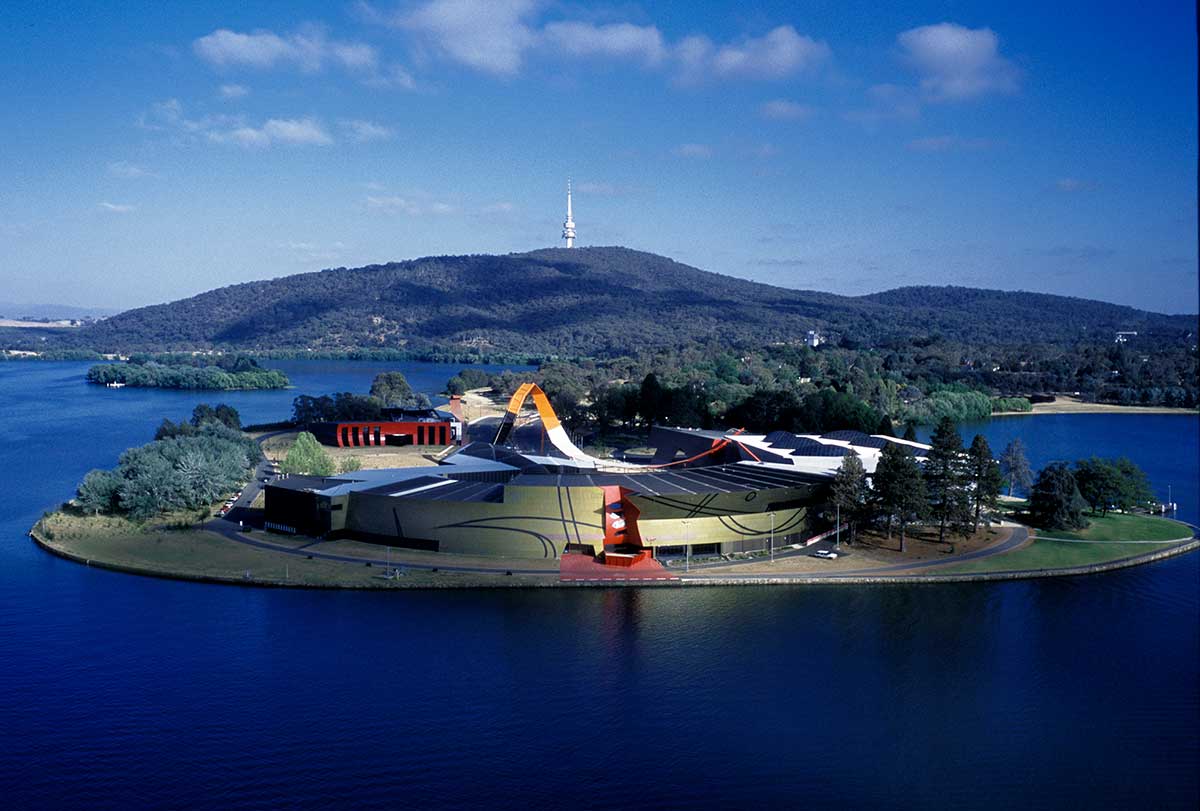 Aerial view of a modern building on a peninsula surrounded by a lake. 