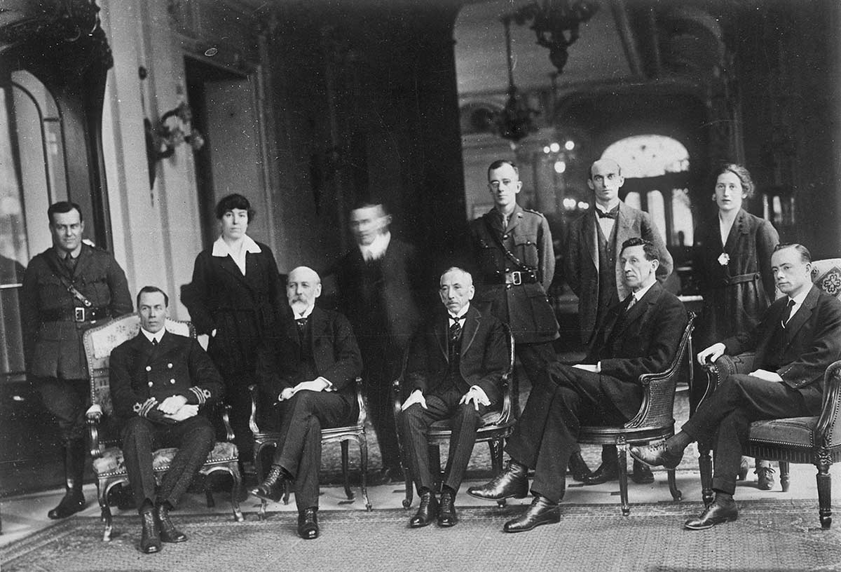 Interior photo of 11 people, with five seated in front and six standing in back – the latter includes two women.