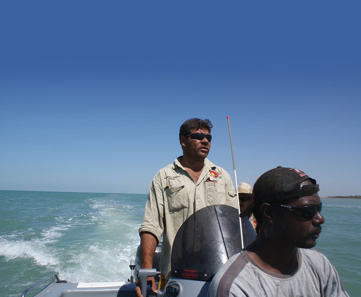 Three men on patrol in a boat.
