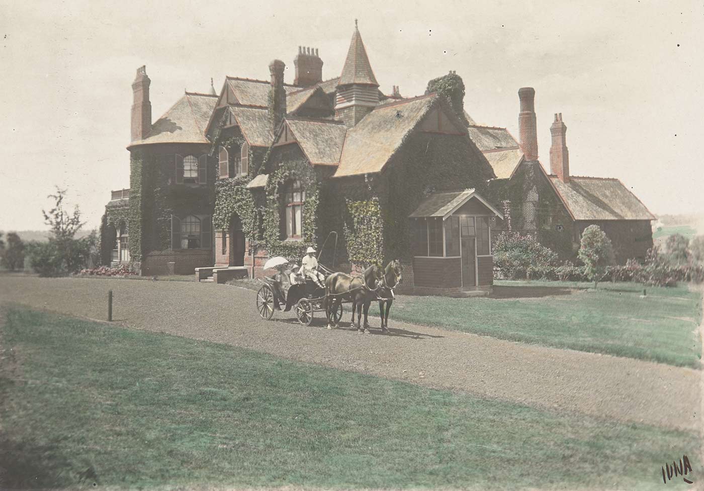 Carriage pulled by two horses on a path in front of a country house. - click to view larger image