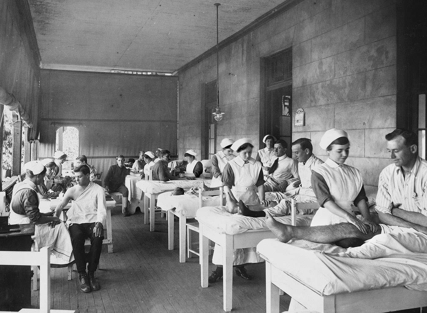 Nurses are tending to wounded soldiers in a ward.