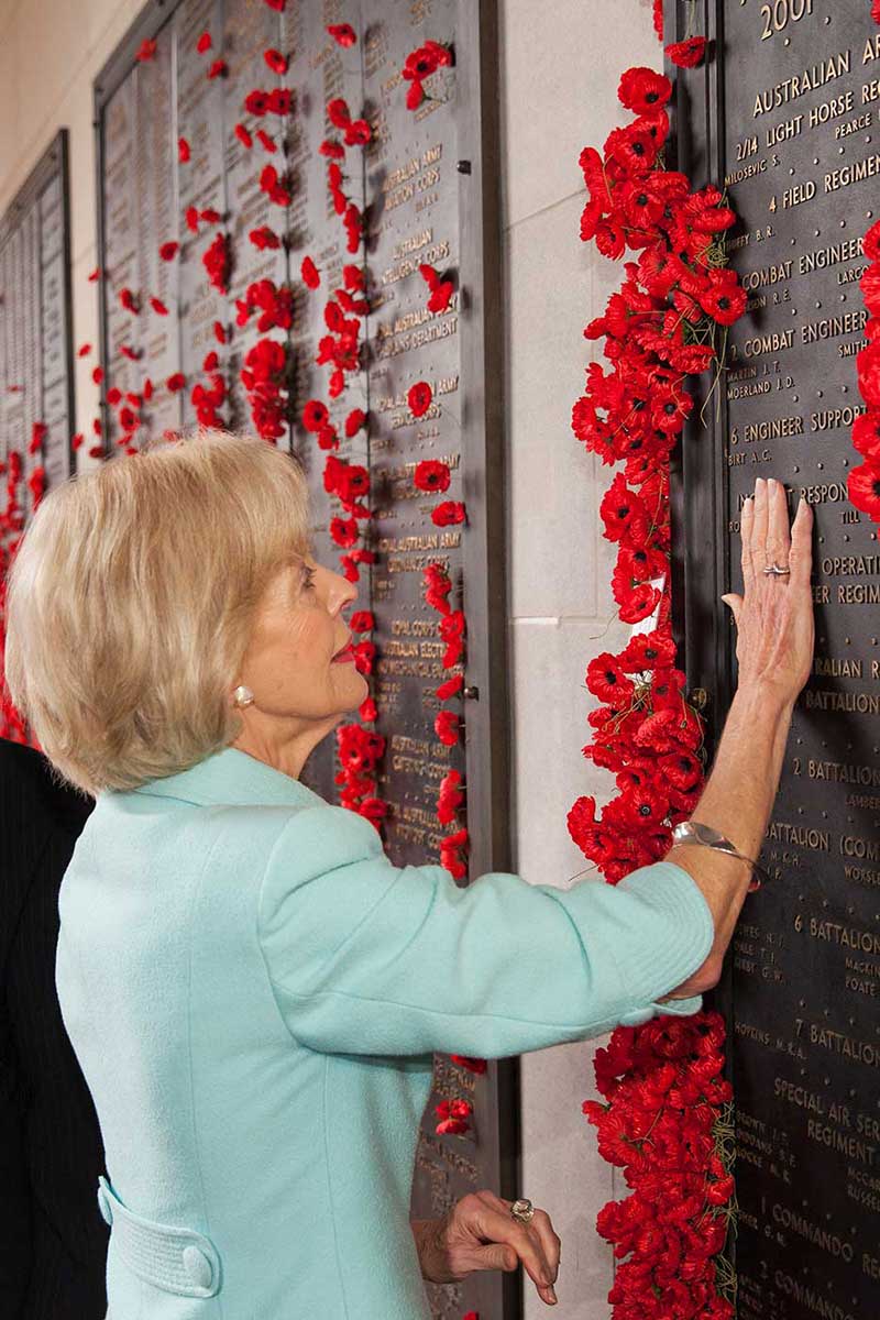 Quentin Bryce places her hand on a commemorative plaque at the Australian War Memorial. - click to view larger image