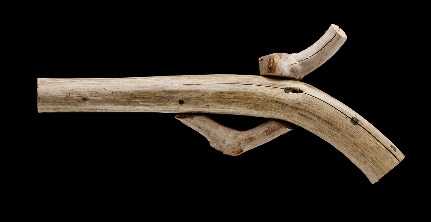 An artwork in the shape of a pistol made from driftwood. - click to view larger image