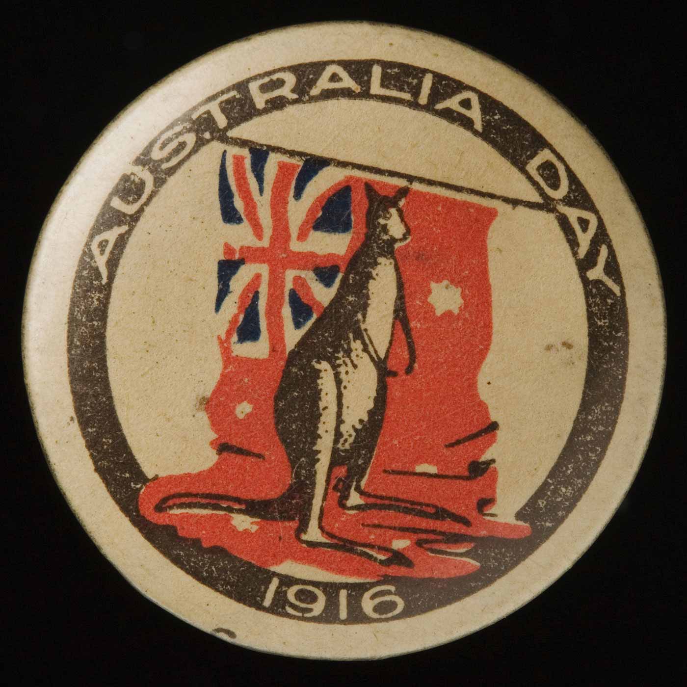 Circular badge with 'Australia Day 1916' printed in a black circular band. The central image shows a kangaroo standing on a red ensign. - click to view larger image