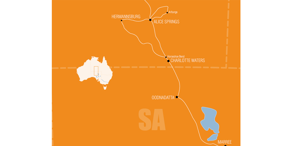 Map outlining the expedition in 1923 through South Australia and the Northern Territory. The stylised map shows the expedition routes as white lines against an earthy yellow background. Lake Eyre is represented as two blue shapes in the bottom right hand corner of the map. Locations such as Marree, Oodnadatta, Alice Springs and Hermannsburg are indicated on the map. The South Australian-Northern Territory border is shown as well as the intersection of the South Australian, Northern Territory and Queensland borders, at the extreme right of the map. A small white map of Australia is at the left hand side of the main map, with a rectangle in it indicating the expedition area.