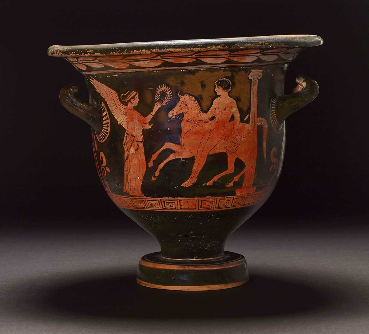 Red-figured ceramic vessel featuring a winged figure facing another figure on a horse. - click to view larger image