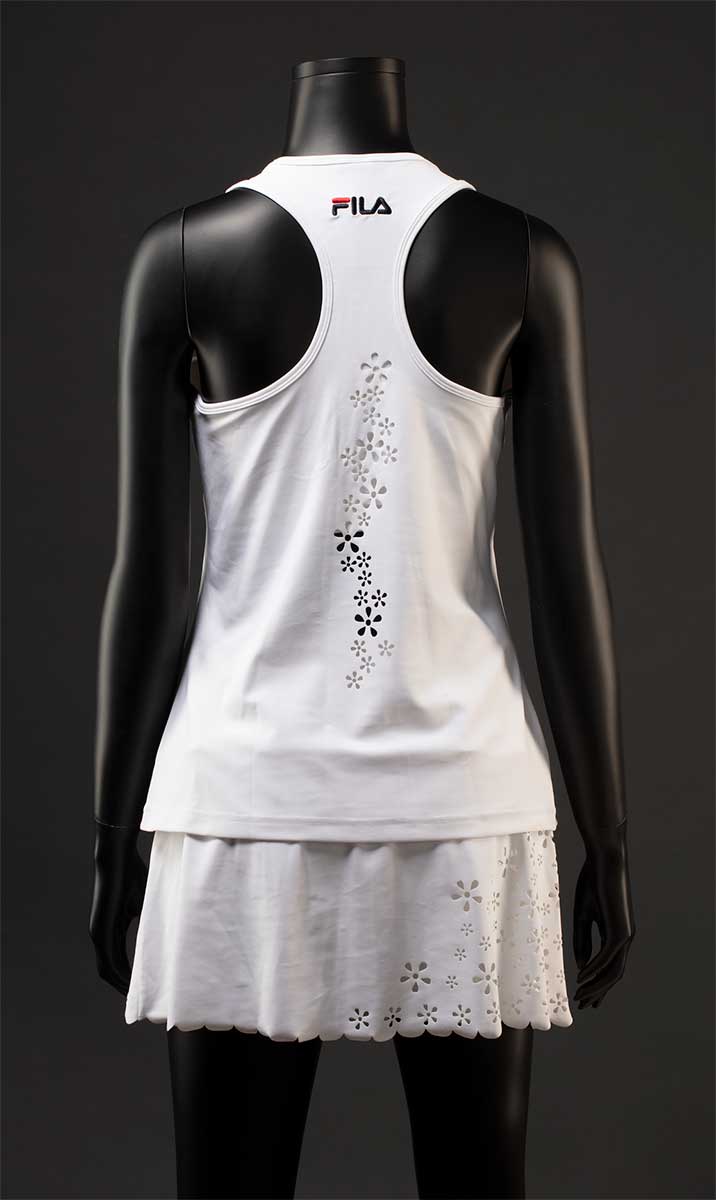 A white Fila 'Trailblazer' tennis outfit consisting of a tank top and skort. The racerback tank top has a laser cut floral decoration at the back. The skort has a laser cut scalloped hem and floral decoration at the front and side. - click to view larger image