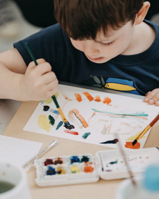 Picture of a child painting on a white piece of paper