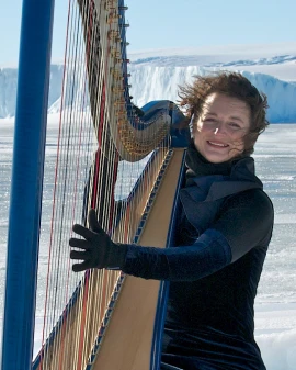 Photo of Alice Giles playing the harp in Antarctica.